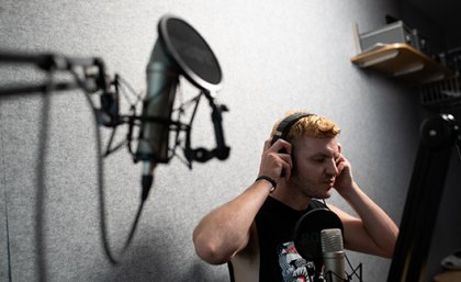 UQ alumnus Stephen Stockwell, the host of Doomscroll Remedy. A man putting on a pair of headphones